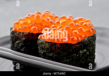 Salmon eggs or Ikura in Japanese style sushi fresh from raw salmond fish in studio lighting. Stock Photo