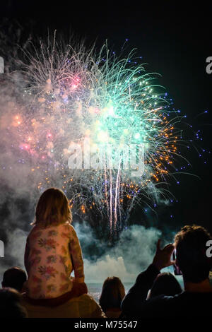 Barcelona, Spain - September 23, 2017: People are watching great fireworks at the coast of Barcelona, Spain during the La Mercè Festival, a large part Stock Photo