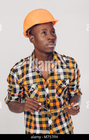 African-American builder uses measuring tape Stock Photo