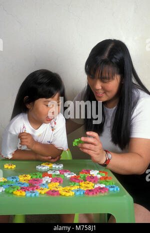 Oriental mother and daughter doing number and letter puzzle together Stock Photo