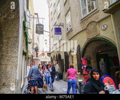 SALZBURG, AUSTRIA - SEPTEMBER 6 2017; People moving through busy narrow street of historic buildings and modern shops in old city Stock Photo