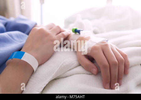 female patient sleeping on the patient bed in the room after surgery at the hospital. Stock Photo