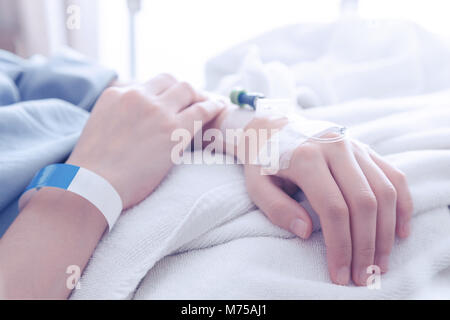 female patient sleeping on the patient bed in the room after surgery at the hospital. vintage photo and film style. Stock Photo