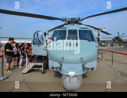 Singapore - Feb 10, 2018. People looking at an Eurocopter EC725 helicopter of the Singapore Air Force (RSAF) in Changi, Singapore. Stock Photo