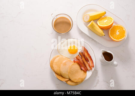 Breakfast plate with pancakes, eggs, bacon and fruit. Stock Photo