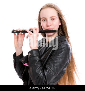 young blond teen girl plays black wooden piccolo flute in studio against white background Stock Photo