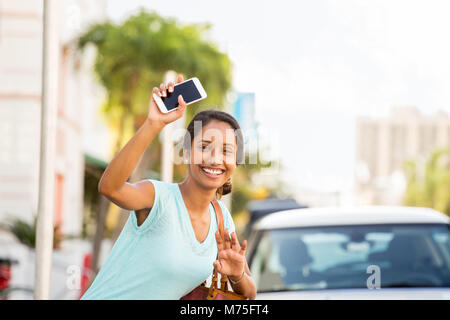 Young woman waving her hand for her ride. Stock Photo