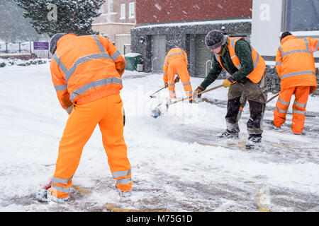 Workmen removing snow from a road into a car park, West Bridgford, Nottinghamshire, England, UK Stock Photo