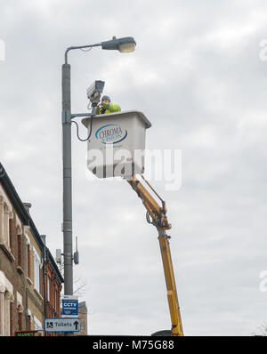 A CCTV camera being installed by a maintenance crew in Earlsfield, London Stock Photo