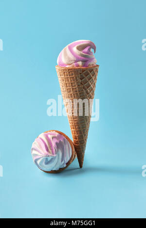 Ice cream in waffle cups, white and purple on light blue background. Stock Photo