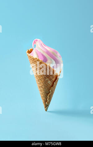 Ice cream in waffle cup, white and purple on light blue background. Stock Photo