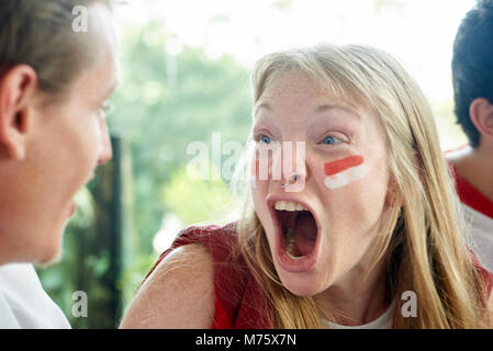 English soccer fans watching televised match together Stock Photo