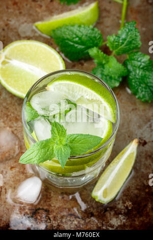 Mojito cocktail or lemonade with lime, mint and ice cubes. Traditional summer refreshing drink. Selective focus Stock Photo