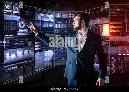Thoughtful programmer looking impressed while working with new device Stock Photo
