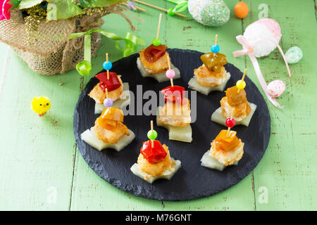 Easter recipe, festive appetizer. Canapes with pineapple, grill chicken, marinated peppers - on the festive table. Stock Photo