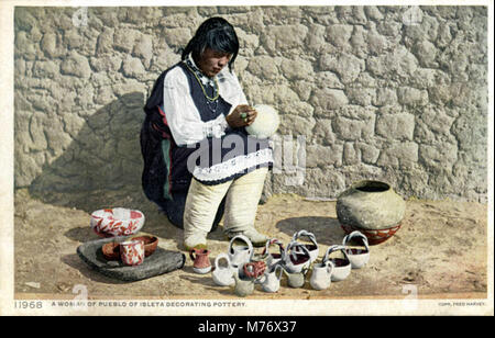 A photograph of a woman from the Pueblo of Isleta, New Mexico, decorating pottery, showcasing traditional craft and cultural heritage of the Pueblo people. Stock Photo