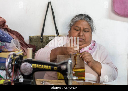 Teotitlan del Valle, Oaxaca, Mexico - A woman stitches handbags at her home in a small Zapotec village. Stock Photo