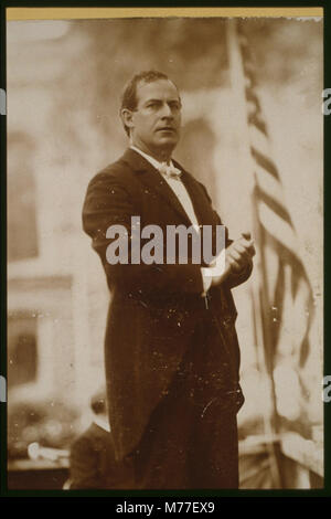 William Jennings Bryan, Democratic party presidential candidate, three-quarter length view standing on stage next to American flag LCCN2001697076 Stock Photo