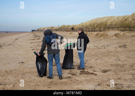 Crosby, Merseyside.  UK Weather. 9th March, 2018.  Network rail 'Social Responsibilty' volunteers beach cleaning at Mariners Way Beach. Employees are given five days' volunteer leave to help any UK registered charities of their choice or a community engagement activity. Squads of workers, who have to pay their own way to the resort, are employed to remove items washed up in the plastic tide brough to land by recent storms. Credit MediaWorldImages/AlamyLiveNews. Stock Photo