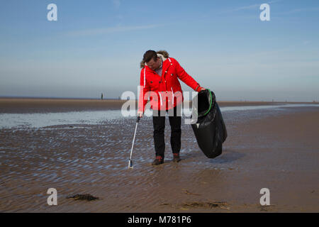 Crosby, Merseyside.  UK Weather. 9th March, 2018.  Saul Brennan a Network rail 'Social Responsibilty' volunteer beach, cleaning at Mariners Way Beach. Employees are given five days' volunteer leave to help any UK registered charities of their choice or a community engagement activity. Squads of workers, who have to pay their own way to the resort, are employed to remove items washed up in the plastic tide brought to land by recent storms. Credit MediaWorldImages/AlamyLiveNews. Stock Photo