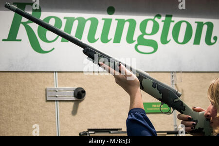 09 March 2018, Germany, Nuremberg: A woman holding a rifle by the American manufacturer Remington at the IWA OutdoorClassics trade show for hunting, shooting sports, equipment for outdoor activities and for civilian and official security applications. Photo: Daniel Karmann/dpa Stock Photo