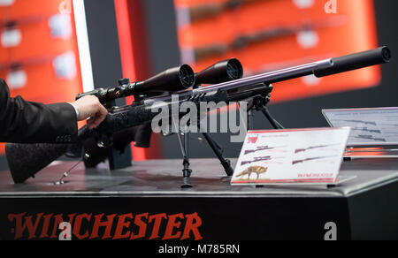 09 March 2018, Germany, Nuremberg: Rifles by the manufacturer Winchester are displayed at the company's stand at the IWA OutdoorClassics trade show for hunting, shooting sports, equipment for outdoor activities and for civilian and official security applications. Photo: Daniel Karmann/dpa Stock Photo