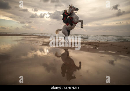 Gaza City, Gaza Strip. 09th Mar, 2018. A Palestinian man rides his horse during an equestrian show at the beach in Gaza City, Gaza Strip, 09 March 2018. Credit: Wissam Nassar/dpa/Alamy Live News Stock Photo