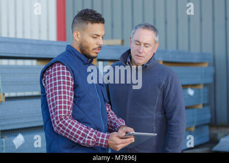 view of two workers working outside on a construction site Stock Photo