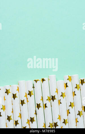 Elegant White Paper Drinking Straws with Golden Stars Pattern Scattered as Border on Turquoise Background. Birthday Party Fun Kids Holiday Celebration Stock Photo