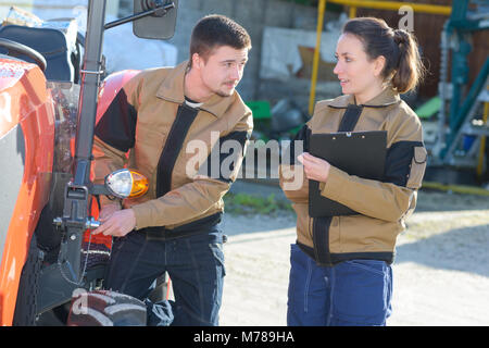 agricultural mechanics checking tractors condition before harvesting Stock Photo