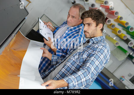 workers on large printer format inkjet working Stock Photo
