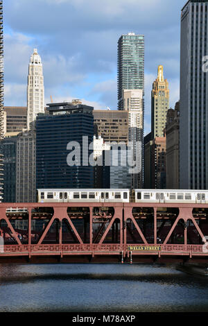 A CTA Brown Line L train crosses the river over the Wells Street bridge on its way out of Chicago's downtown Loop. Stock Photo