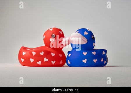 Valentine bath love ducks with hearts on their bodies, whispering, kissing on cheek Stock Photo