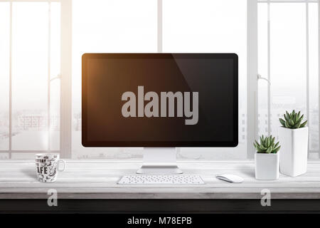 Computer display with blank screen for mockup in office or work room. Window and sun light in background. Cup of coffee and two plants beside. Stock Photo