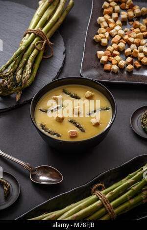 Creamy asparagus soup on black background Stock Photo