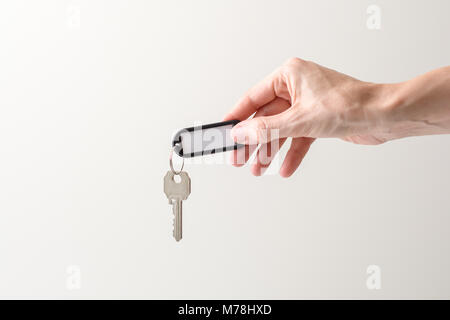woman hand holding a key of a house with a white space to write in and white backgroung Stock Photo