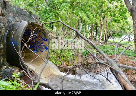 Water flowing out of a large storm water drain after storms and heavy rainfall into the Ross river, Aplins weir, Townsville, Queensland, Australia Stock Photo