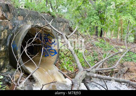 Water flowing out of a large storm water drain after storms and heavy rainfall into the Ross river, Aplins weir, Townsville, Queensland, Australia Stock Photo