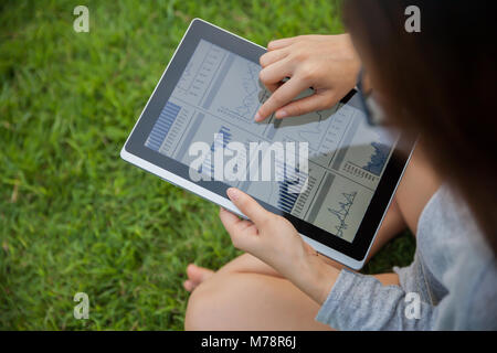The woman checking reported profits in the garden. Stock Photo