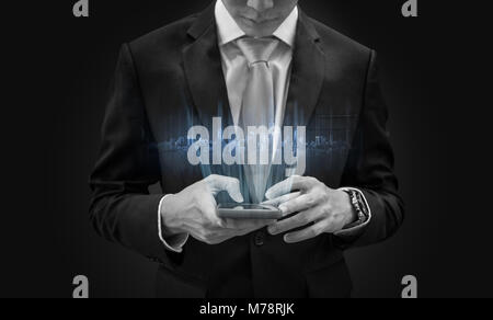 Young businessman using mobile smart phone, with futuristic buildings hologram Stock Photo