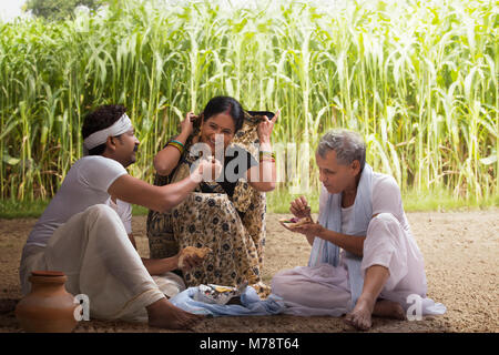 Indian farmer family having lunch in field Stock Photo
