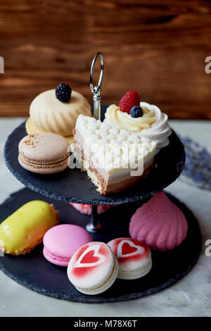 Cakes on a dark slate bunk stand.Desserts. Sweet table Stock Photo