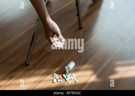 The man committing suicide by overdosing on medication. Close up of overdose pills and addict. Stock Photo