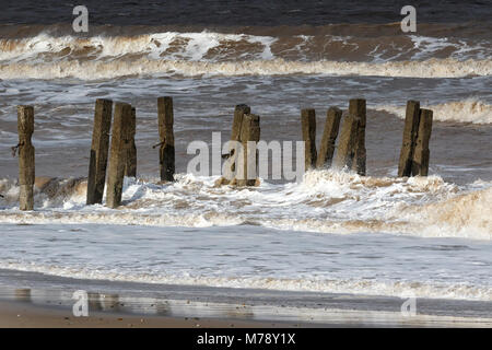 Waves crashing through broken revetments, Walcott Norfolk Stock Photo