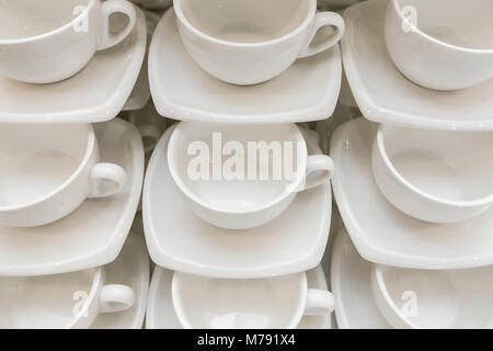 Many rows clean white coffee cup, tea spoon and saucer on table. Empty mug set in row prepare for coffee break Stock Photo