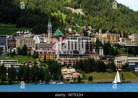 View on the village of St. Moritz on the slopes of the Albula Alps. Sailboat with white sails sailing on the lake in summer. Switzerland Stock Photo