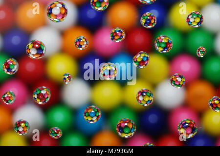 multicolored bubble gum candy reflected in drops of water on a blurred background Stock Photo