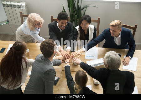 Multiracial business people put hands together at group team mee Stock Photo