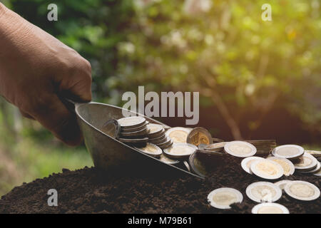 Aluminum scoop with stack coin on ground for growing business. Accounting and financial concept. Stock Photo
