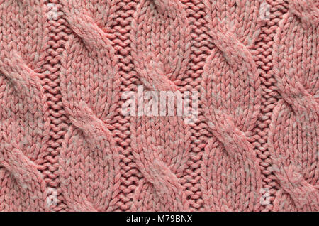 Knit Texture of Pink Wool Knitted Fabric with Regular Cable Knitted Pattern. Blank Background Stock Photo